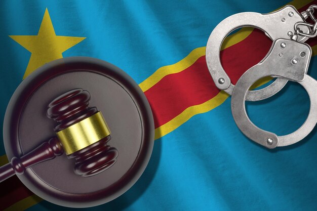 Photo drapeau de la république démocratique du congo avec maillet de juge et menottes dans une pièce sombre concept de contexte criminel et punitif pour les sujets de jugement