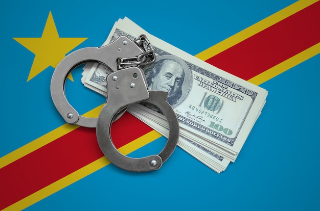 Drapeau de la République démocratique du Congo avec des menottes et un paquet de dollars. La corruption monétaire dans le pays. Crimes financiers