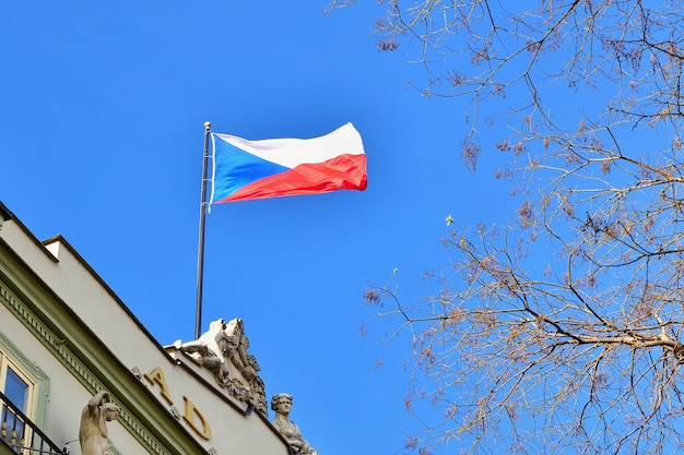 Le drapeau de la République tchèque sur un bâtiment avec un ciel bleu et le soleil en arrière-plan