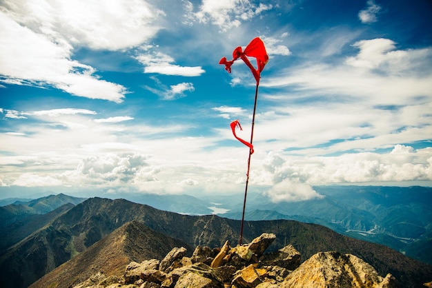 Drapeau rouge au sommet de la montagne avec un ciel bleu