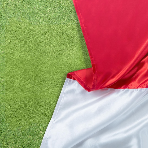 Le drapeau rouge et blanc du drapeau indonésien avec fond d'herbe verte
