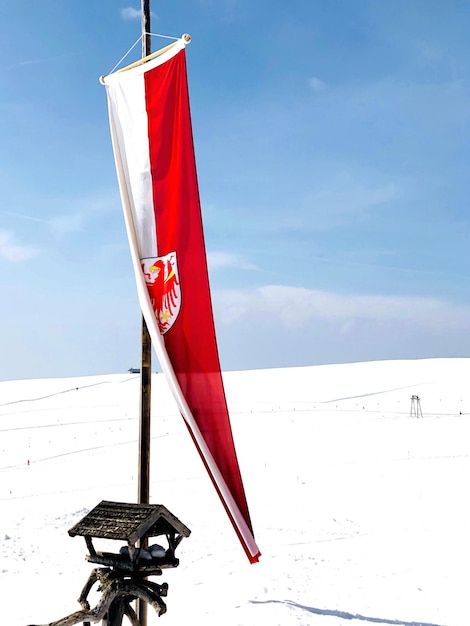 Drapeau rouge sur une terre couverte de neige contre le ciel