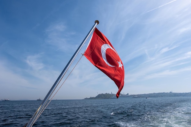 Drapeau rouge de la Turquie au premier plan des mouettes volantes et de la mer Noire