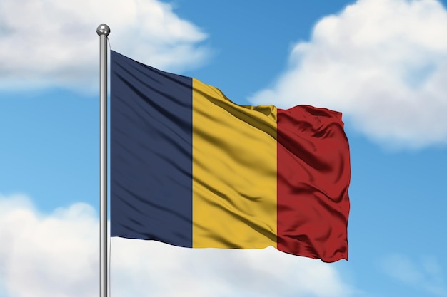 Un drapeau de la Roumanie contre un ciel bleu.