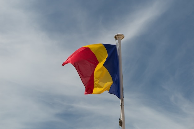 Drapeau de la Roumanie sous le ciel bleu