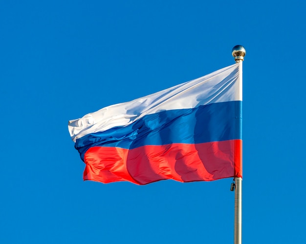 Drapeau russe sur fond de ciel bleu.