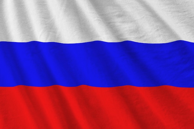 Drapeau de la Russie avec de grands plis agitant de près sous la lumière du studio à l'intérieur Les symboles officiels et les couleurs de la bannière
