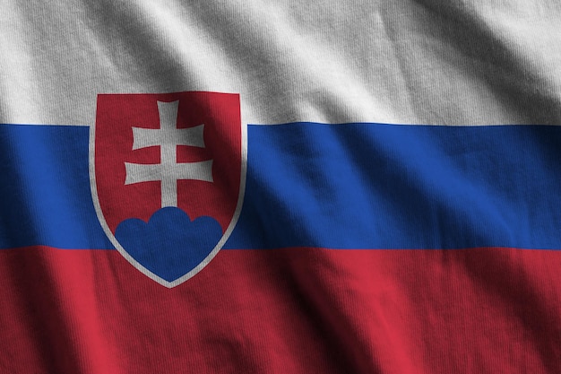 Photo drapeau slovaque avec de grands plis agitant de près sous la lumière du studio à l'intérieur les symboles officiels et les couleurs de la bannière
