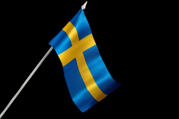 Le drapeau suédois agitant le drapeau de la suède sur fond noir se développe et vole au vent