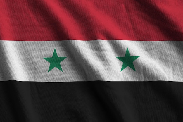 Drapeau syrien avec de grands plis agitant de près sous la lumière du studio à l'intérieur Les symboles officiels et les couleurs de la bannière