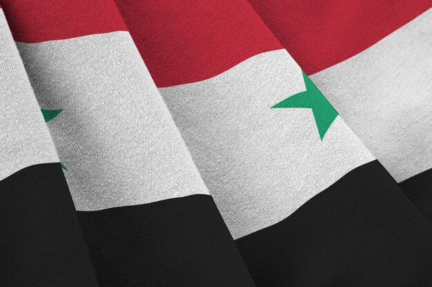 Photo drapeau syrien avec de grands plis agitant de près sous la lumière du studio à l'intérieur les symboles officiels et les couleurs de la bannière