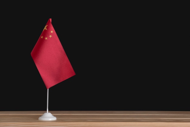 Drapeau de table national de la Chine sur fond noir. Drapeau rouge avec des étoiles.