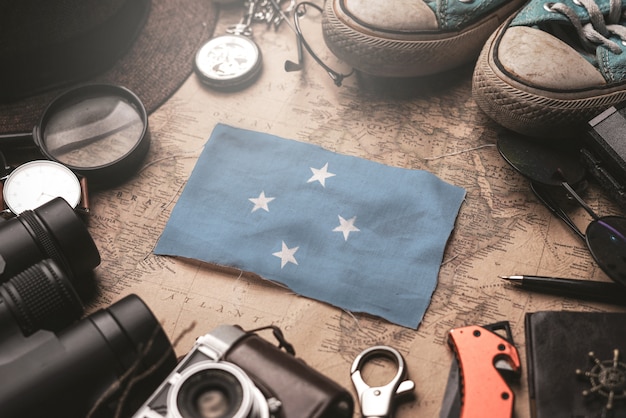 Drapeau des États fédérés de Micronésie entre les accessoires du voyageur sur l'ancienne carte vintage. Concept de destination touristique.