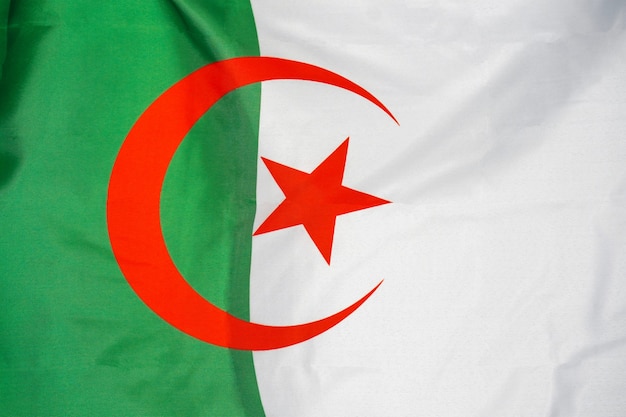 Photo drapeau de la texture du tissu de l'algérie. drapeau de l'algérie ondulant dans le vent. le drapeau algérien est représenté sur un tissu de sport avec de nombreux plis. bannière de l'équipe sportive