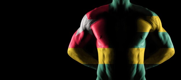 Drapeau togolais sur torse masculin musclé avec abs, fond noir