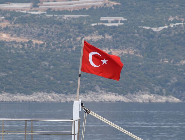 Photo le drapeau de la turquie flotte dans le vent sur le pont d'un yacht de plaisance