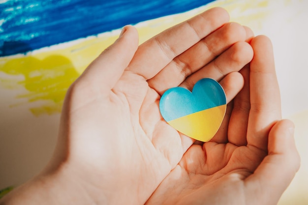 Drapeau de l'Ukraine Coeur bleu jaune dans les paumes de l'enfant