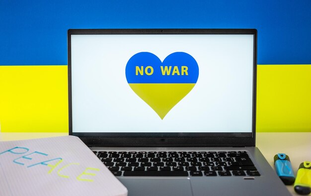 Drapeau de l'Ukraine sur le fond et à l'intérieur d'un cœur peint sur l'écran numérique Guerre avec la Russie Cyber-attaque sanctions effondrement économique Message pour la paix mondiale