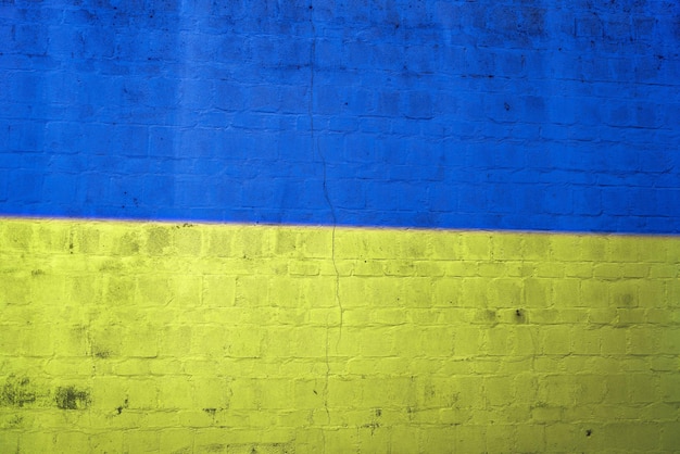 Drapeau de l'Ukraine mur de briques peintes fond de texture grungy bleu jaune