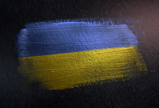 Drapeau de l&#39;Ukraine en peinture à brosse métallique sur le mur sombre de Grunge
