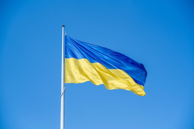 Photo drapeau ukrainien dans le vent sur fond de ciel bleu grand drapeau national jaune bleu de l'ukraine grand