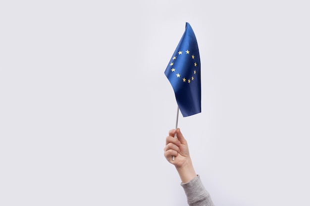 Drapeau de l'Union européenne dans la main de l'enfant sur fond blanc