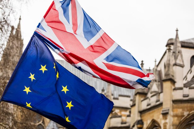 Drapeau de l'Union européenne et de l'Union Jack britannique volant ensemble Un symbole du référendum de l'UE sur le Brexit