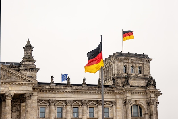 Des drapeaux allemands agitant au sommet du Reichstag avec un dôme en verre Bâtiment gouvernemental sur la Platz der Republik à Berlin Le siège du Bundestag en Allemagne Copier l'espace
