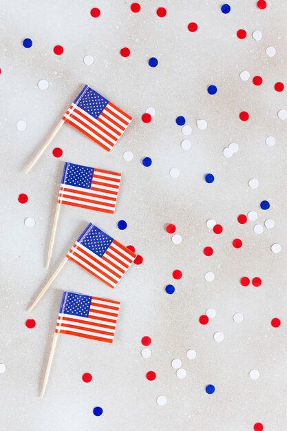 Photo drapeaux américains à plat sur le fond blanc avec des confettis joyeux jour de l'indépendance usa high