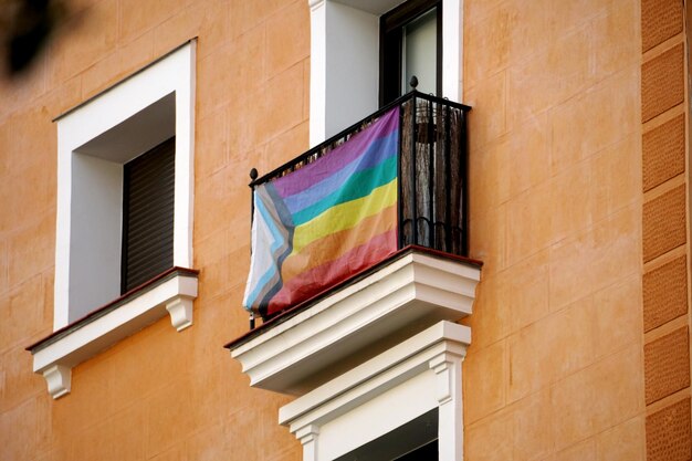 Drapeaux arc-en-ciel sur les balcons d'une maison et sur des mains humaines