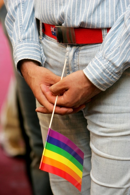 Drapeaux arc-en-ciel sur les balcons d'une maison et sur des mains humaines