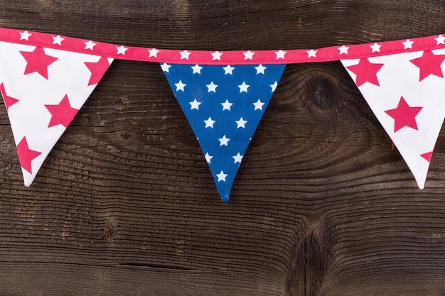 Drapeaux de banderoles de triangle de fête suspendus à la corde sur le vieux fond en bois