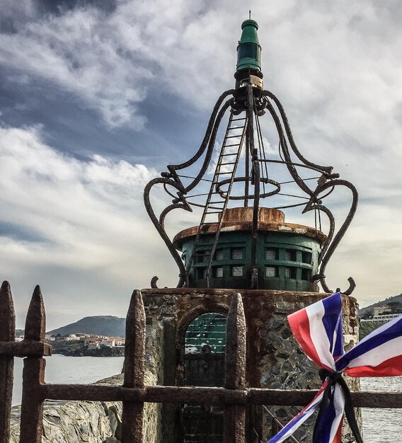 Photo drapeaux contre le phare par mer