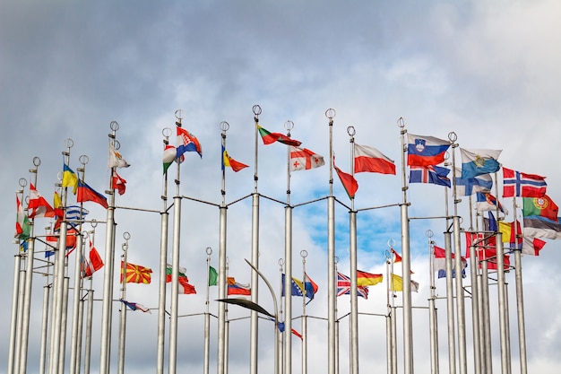 Drapeaux de différents pays dans un tour contre ciel nuageux