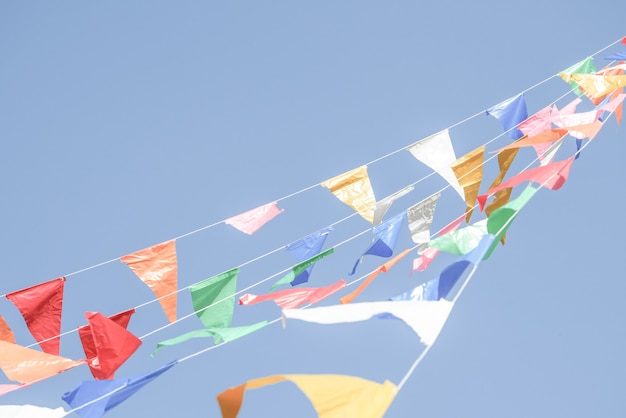 Drapeaux de fête colorés banderoles suspendus sur un ciel bleu pour la décoration de vacances