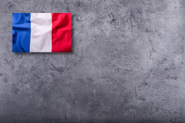 Drapeaux de la France sur fond de béton.