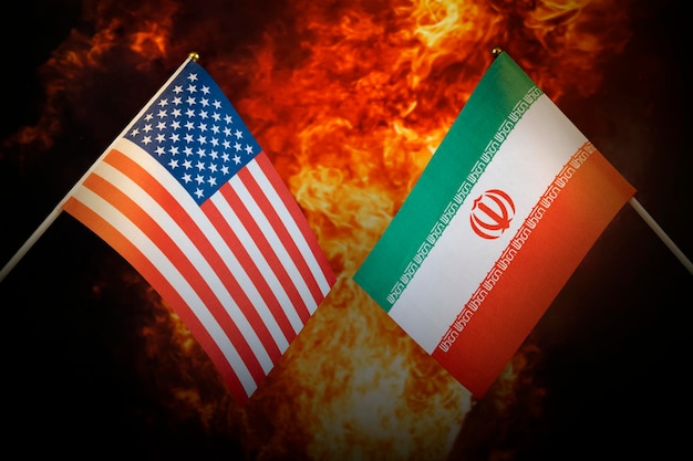 Drapeaux de l'Iran et des États-Unis d'Amérique sur fond d'explosion de feu Le concept d'inimitié et de guerre entre pays Relations politiques tendues
