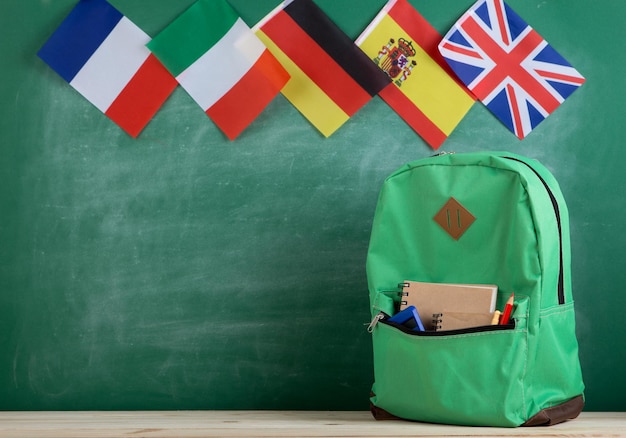 Drapeaux De Sac à Dos De L'espagne Et D'autres Pays Et Fournitures Scolaires Sur Le Fond Du Tableau Noir