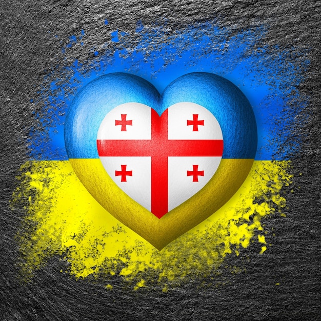 Drapeaux de l'Ukraine et de la Géorgie Deux coeurs aux couleurs des drapeaux sont peints sur la pierre