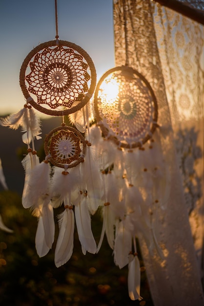 Dreamcatcher blanc dans le ciel du coucher du soleil, amulette indigène américaine