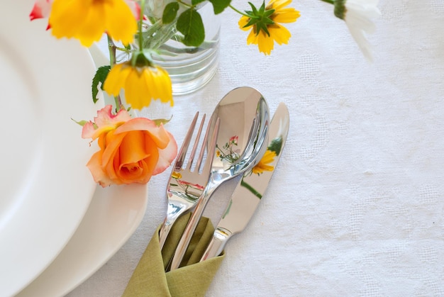 Dressage de table avec assiettes argenterie et fleurs