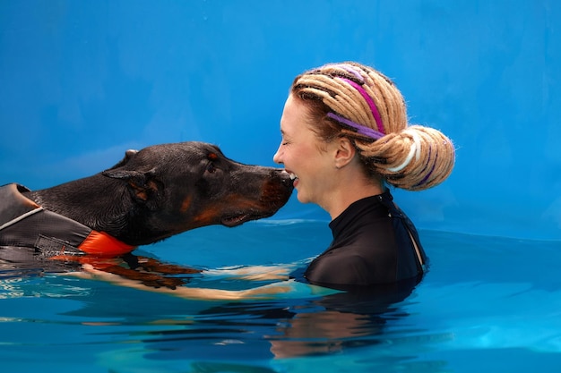 Dresseur de chiens à la piscine apprenant au chien à nager