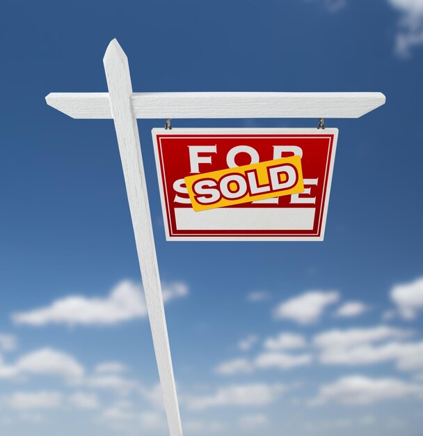Photo À droite, un panneau immobilier à vendre sur un ciel bleu avec des nuages