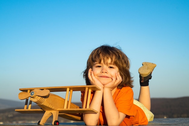 Drôle d'enfant ou d'enfant petit garçon pilote jouer avec la liberté de démarrage de l'avion jouet et les rêves insouciants de fl