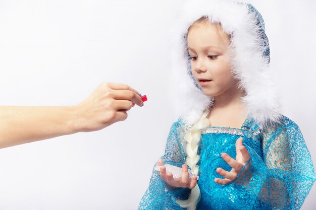 Drôle enfant fille en costume d'Elza regardant des bonbons