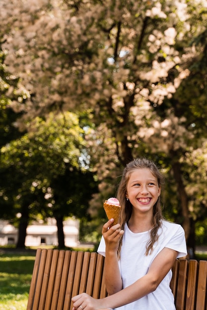 Drôle enfant fille s'amuser avec un cornet de crème glacée dans une tasse à gaufres