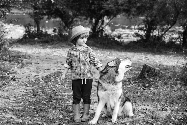 Drôle enfant garçon avec chien marcher ensemble sur la colline verte portrait d'été d'heureux mignon enfant fils avec do