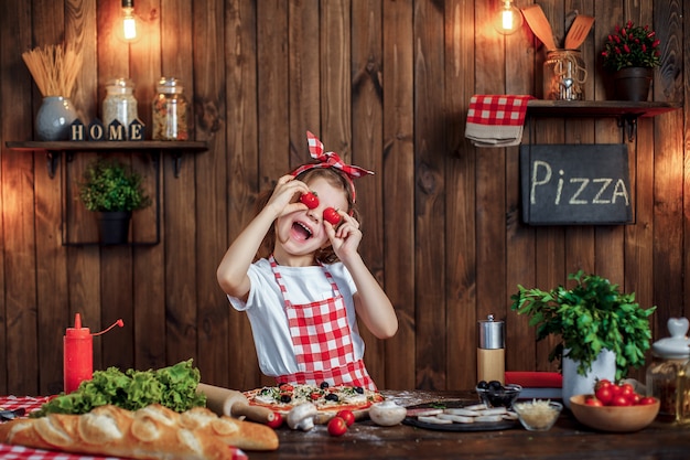 Drôle fille cuisine pizza et tromper avec des tomates