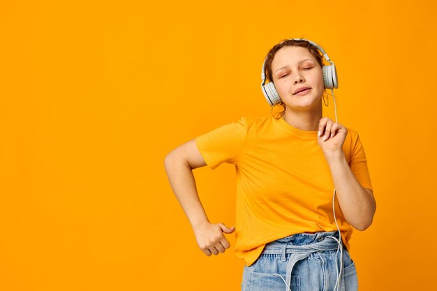 Drôle de fille écoutant de la musique sur un casque style jeunesse fond jaune inchangé