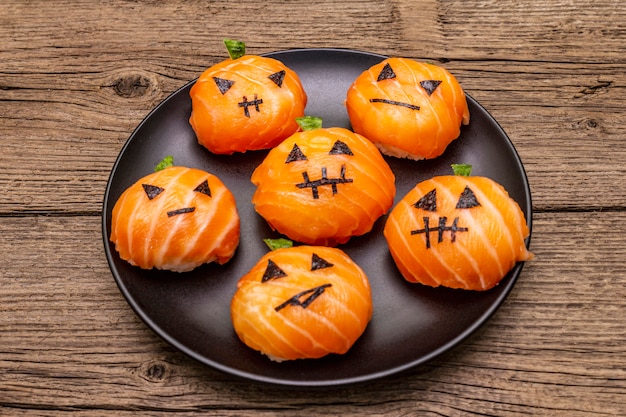 Photo drôle halloween sushi pumpkins jack o lantern, sushi monsters. sushi temari, boules de sushi. des aliments sains pour les enfants